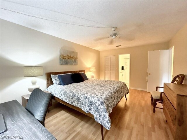 bedroom featuring a textured ceiling, a closet, wood-type flooring, and ceiling fan