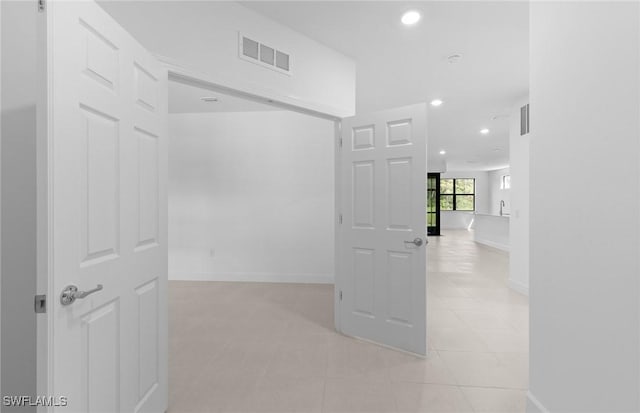 corridor featuring baseboards, light tile patterned flooring, visible vents, and recessed lighting