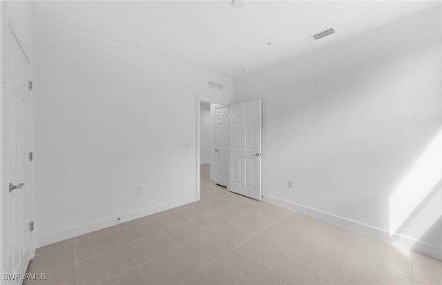 unfurnished bedroom featuring light tile patterned floors, baseboards, and visible vents