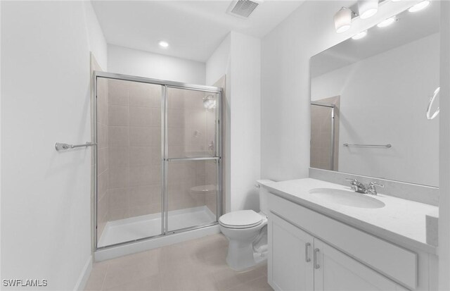 bathroom with tile patterned floors, toilet, a shower with door, and vanity