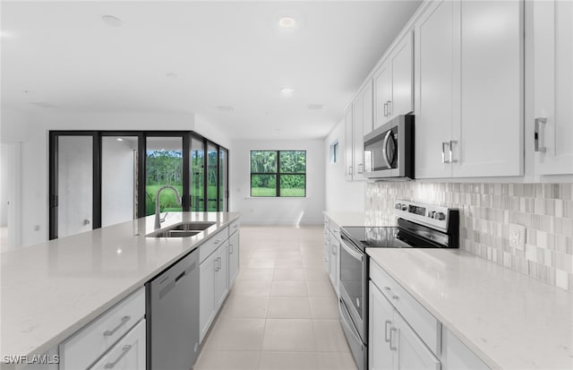 kitchen featuring appliances with stainless steel finishes, light stone counters, and white cabinets