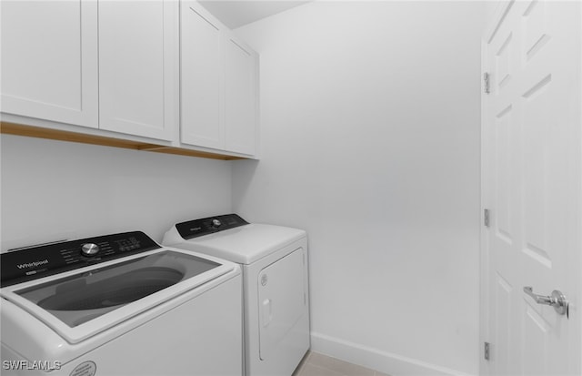 washroom with washing machine and clothes dryer and cabinets