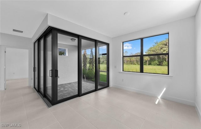 unfurnished room with visible vents, baseboards, and light tile patterned floors