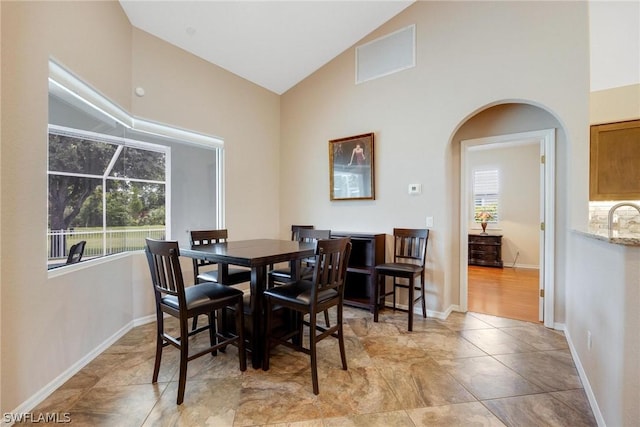 dining room featuring sink and lofted ceiling