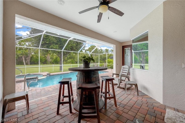 view of pool with glass enclosure and a patio area