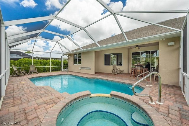 view of swimming pool with an in ground hot tub, an outdoor bar, glass enclosure, and a patio