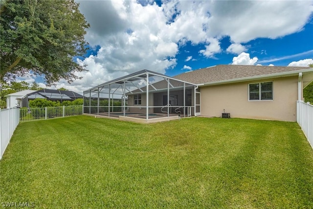 back of house featuring a patio area, a lanai, and a yard