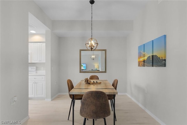 dining area featuring an inviting chandelier and light hardwood / wood-style floors