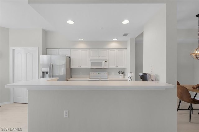 kitchen featuring stainless steel fridge with ice dispenser, white cabinetry, kitchen peninsula, pendant lighting, and range