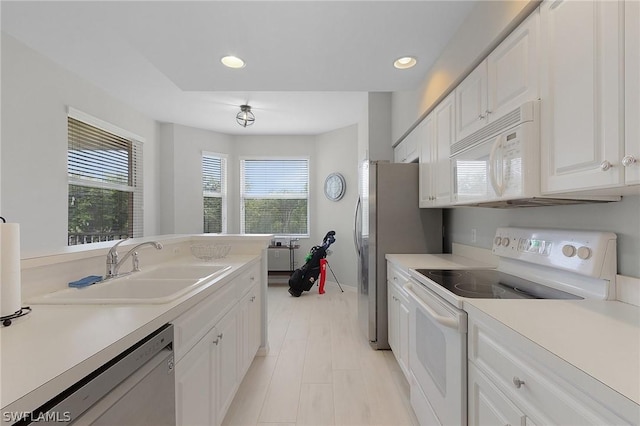 kitchen featuring sink, white appliances, and white cabinets