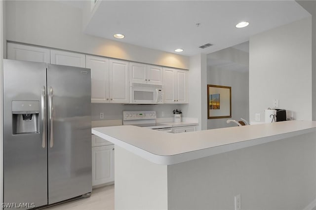 kitchen featuring white cabinetry, kitchen peninsula, and white appliances