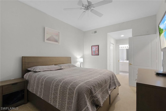 bedroom featuring ensuite bathroom, ceiling fan, and light carpet