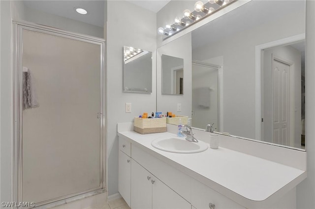 bathroom with tile patterned floors, a shower with shower door, and vanity