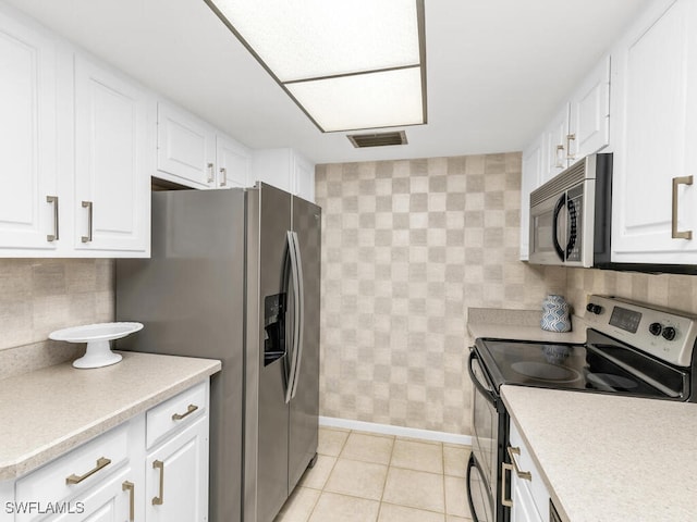 kitchen with white cabinetry, tasteful backsplash, stainless steel appliances, and light tile patterned flooring