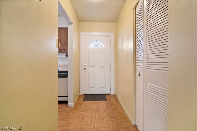 entryway with light parquet floors and a textured ceiling