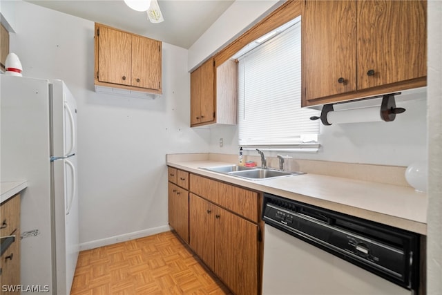 kitchen with white appliances, sink, and light parquet flooring