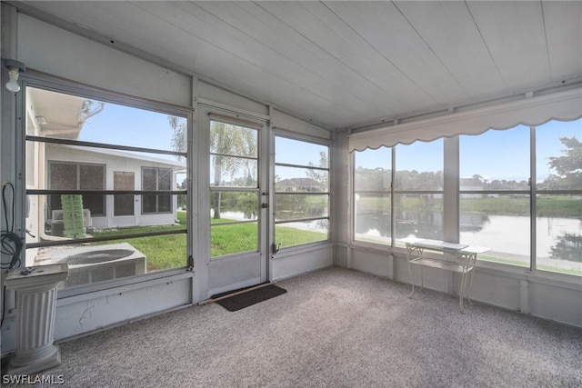 unfurnished sunroom featuring vaulted ceiling and a water view