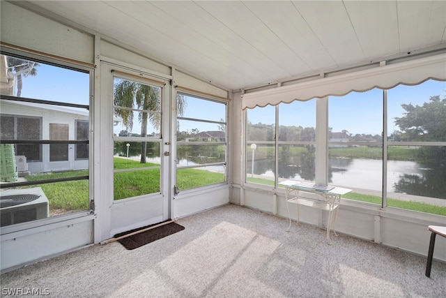 unfurnished sunroom featuring a wealth of natural light and a water view