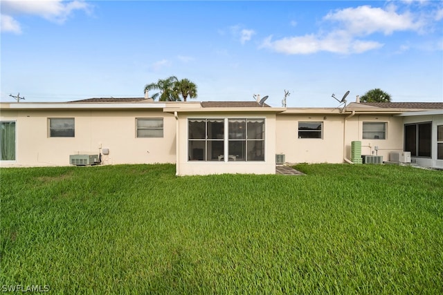 rear view of house featuring a lawn and central air condition unit