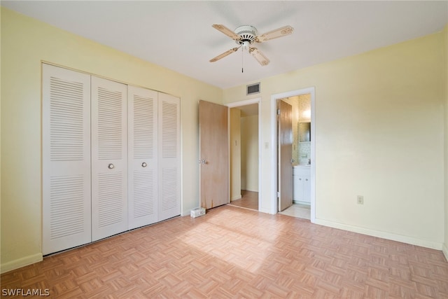 unfurnished bedroom featuring ceiling fan, ensuite bath, and light parquet flooring