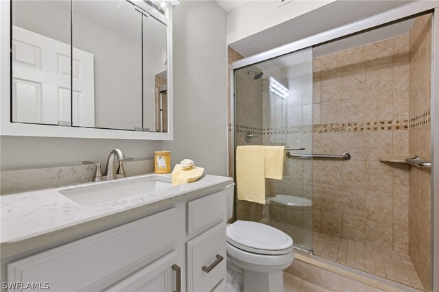 bathroom featuring tile patterned floors, vanity, toilet, and walk in shower