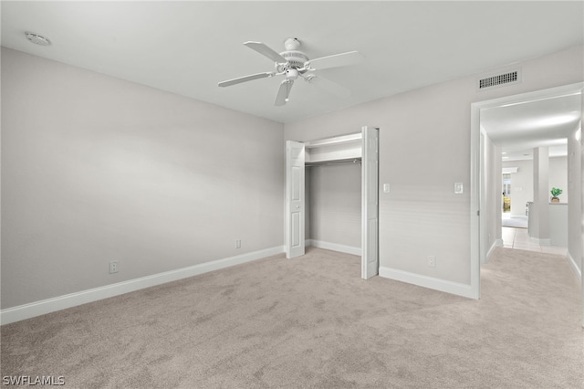 unfurnished bedroom with ceiling fan, light carpet, and a closet