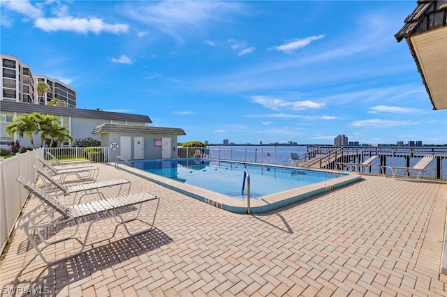 view of swimming pool featuring a water view and a patio area