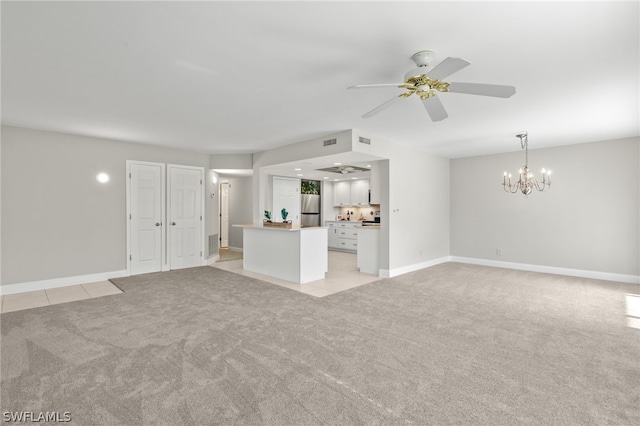 unfurnished living room featuring ceiling fan with notable chandelier and light carpet