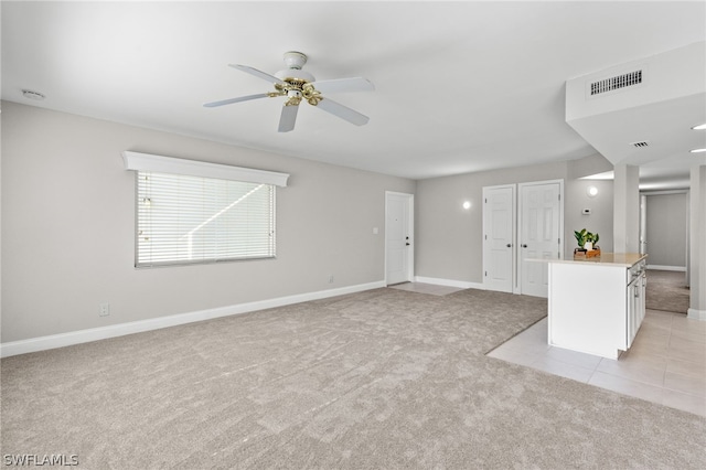 unfurnished living room featuring light colored carpet and ceiling fan