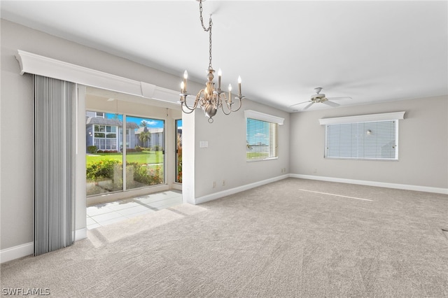 carpeted spare room featuring ceiling fan with notable chandelier