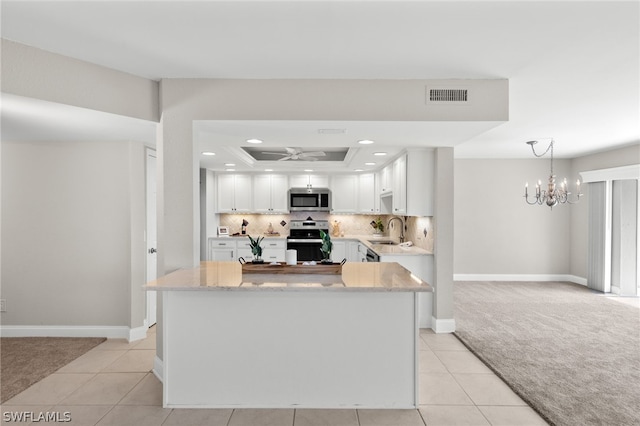 kitchen with ceiling fan with notable chandelier, white cabinets, light tile patterned floors, and appliances with stainless steel finishes