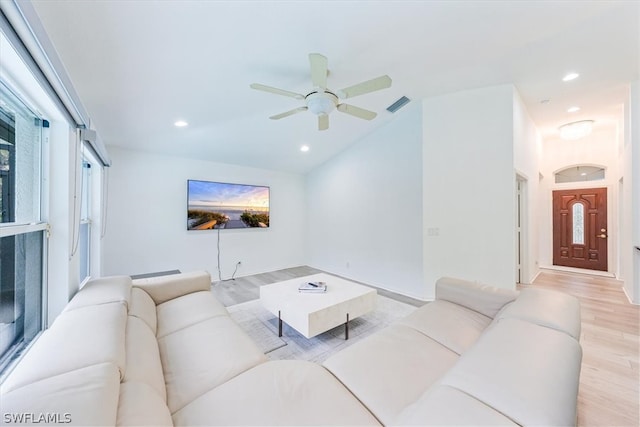 living room with ceiling fan, light hardwood / wood-style floors, and lofted ceiling