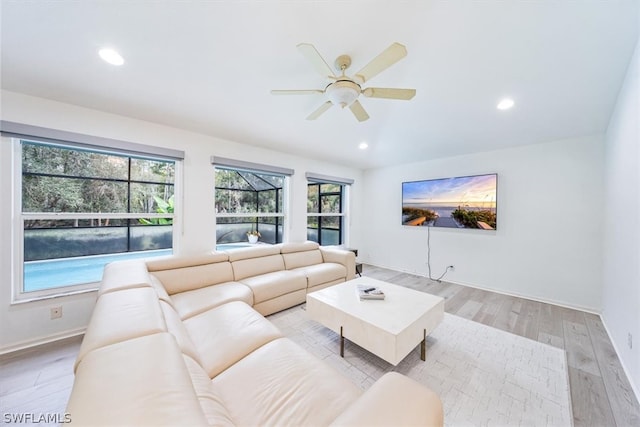 living room featuring plenty of natural light, ceiling fan, and light hardwood / wood-style flooring