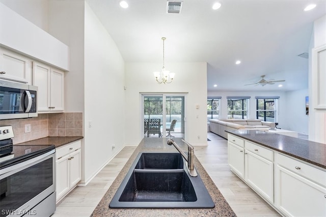 kitchen with light hardwood / wood-style floors, ceiling fan with notable chandelier, stainless steel appliances, backsplash, and sink