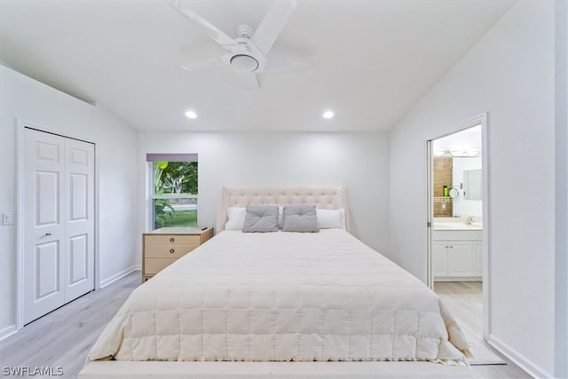 bedroom featuring lofted ceiling, light hardwood / wood-style flooring, a closet, ensuite bathroom, and ceiling fan