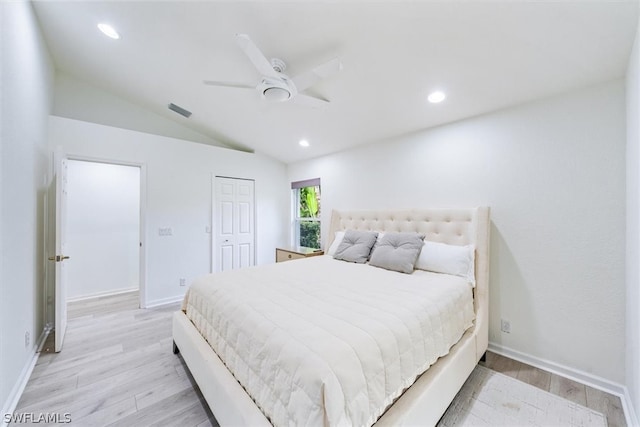 bedroom with lofted ceiling, a closet, ceiling fan, and light hardwood / wood-style flooring