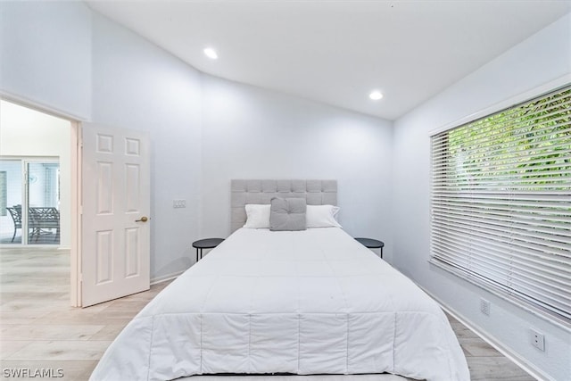 bedroom with vaulted ceiling and light hardwood / wood-style flooring