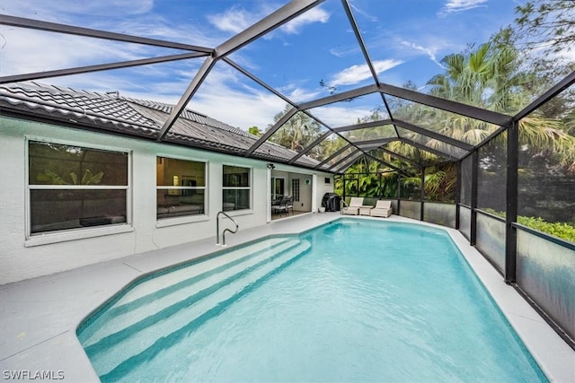 view of swimming pool featuring a lanai and a patio area