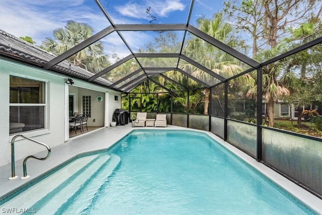 view of swimming pool with a patio area and a lanai