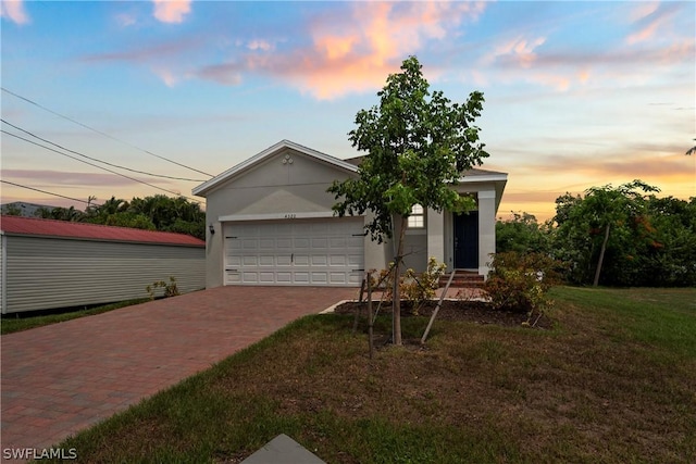 view of front of home featuring a garage and a yard