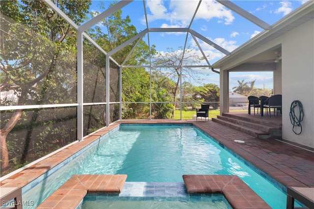 view of swimming pool with a lanai, ceiling fan, and a patio