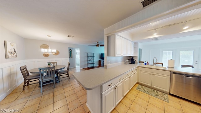 kitchen with kitchen peninsula, light tile patterned floors, dishwasher, and sink