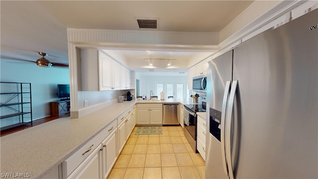 kitchen with white cabinets, sink, ceiling fan, appliances with stainless steel finishes, and kitchen peninsula