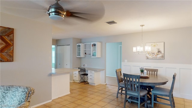 dining area featuring light tile patterned floors and ceiling fan with notable chandelier