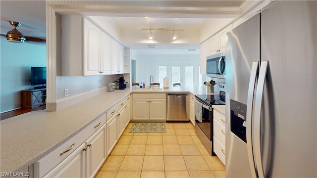 kitchen featuring white cabinetry, sink, stainless steel appliances, kitchen peninsula, and light tile patterned floors