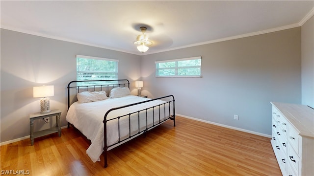 bedroom with ceiling fan, light wood-type flooring, and ornamental molding