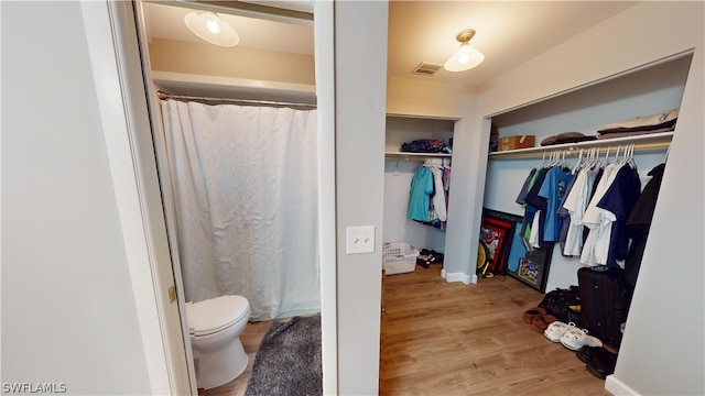 bathroom featuring hardwood / wood-style flooring and toilet