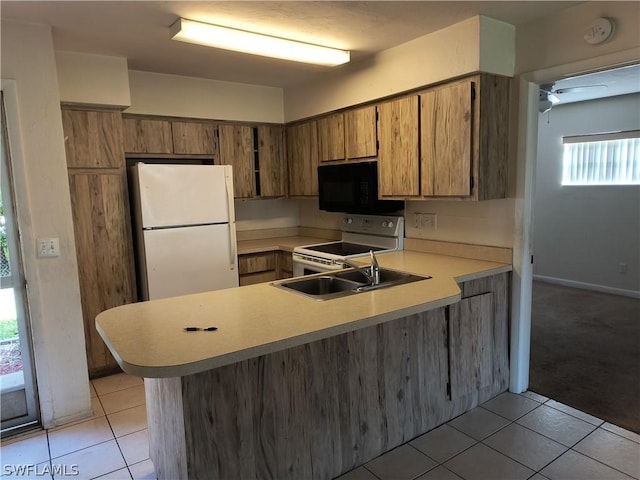 kitchen with sink, white appliances, kitchen peninsula, and light tile patterned floors