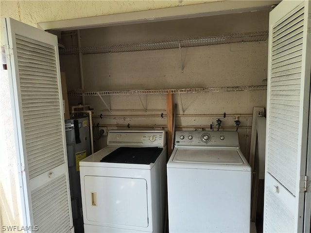 laundry room with washing machine and dryer and water heater