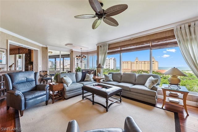 living room featuring hardwood / wood-style flooring, ceiling fan with notable chandelier, and ornamental molding